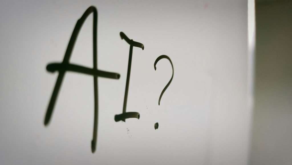 Handwritten AI question mark on whiteboard exploring what artificial intelligence tools are for new users