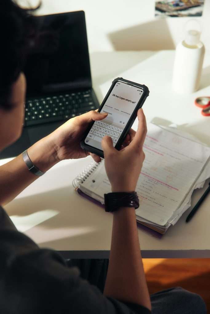 Closeup hands typing message on smartphone screen interacting with AI chat tool app