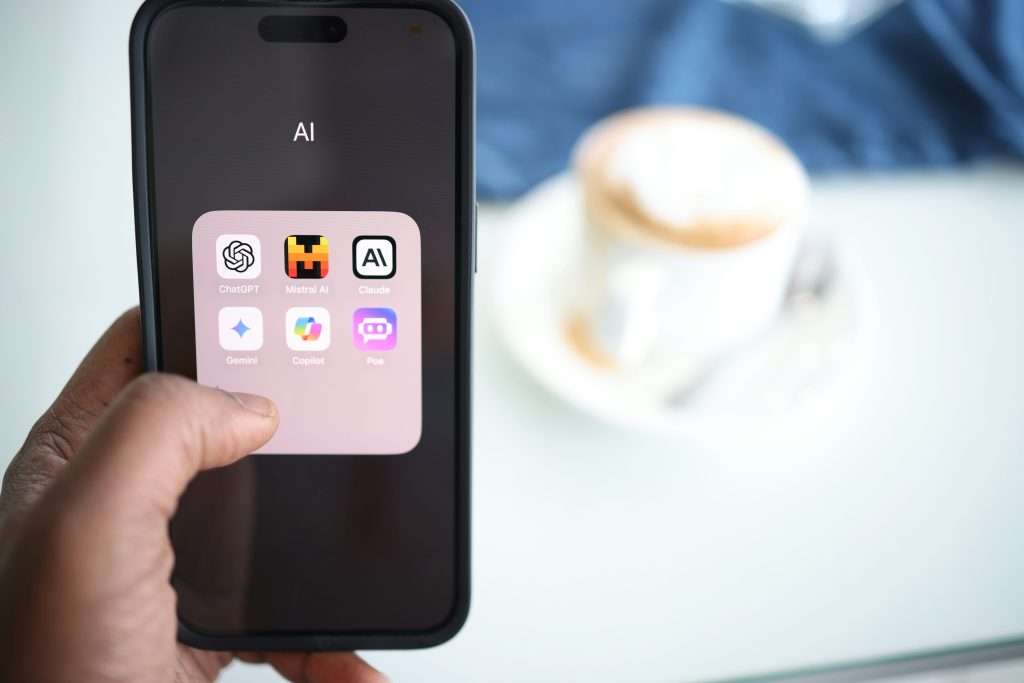 Smartphone screen displaying folder of top popular AI chat and productivity apps for beginners