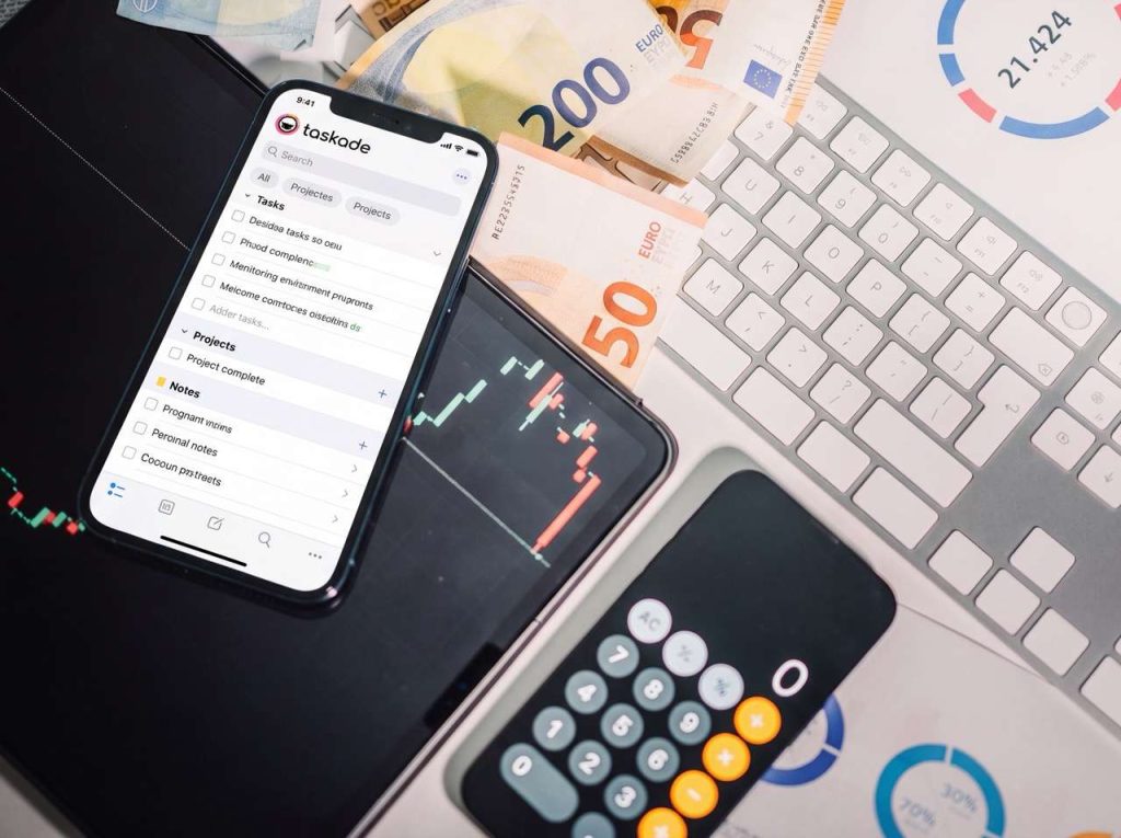 Taskade mobile app interface on smartphone with Euro cash, calculator and financial charts, finance manager manages loan tracking and month-end payment reconciliation